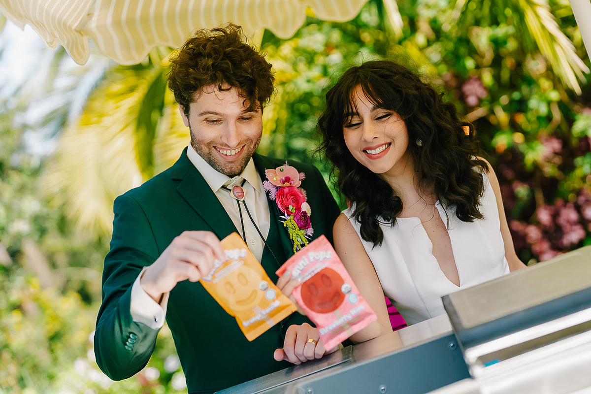 Bride and groom couple standing behind a counter with Benni Pops frozen desserts