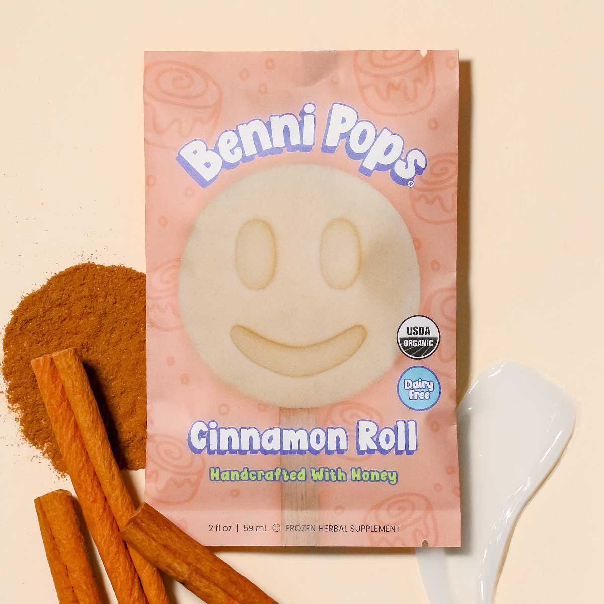 Benni Pops Cinnamon Roll package with cinnamon sticks and ground cinnamon on a neutral background