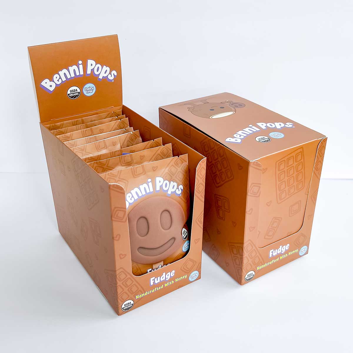 Benni Pops Fudge is an organic, dairy-free frozen treat made with honey and designed for better-for-you dessert lovers. The image features the Fudge flavor in a branded freezer display box with matching case packaging for retail shelves.