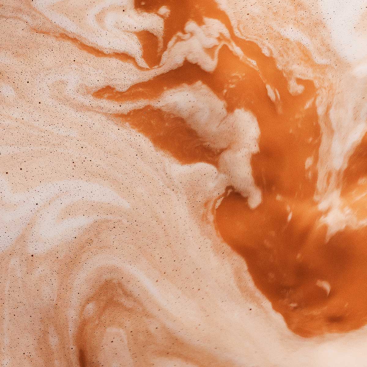 Smooth swirl of creamy orange mixture with soft marbling and airy texture