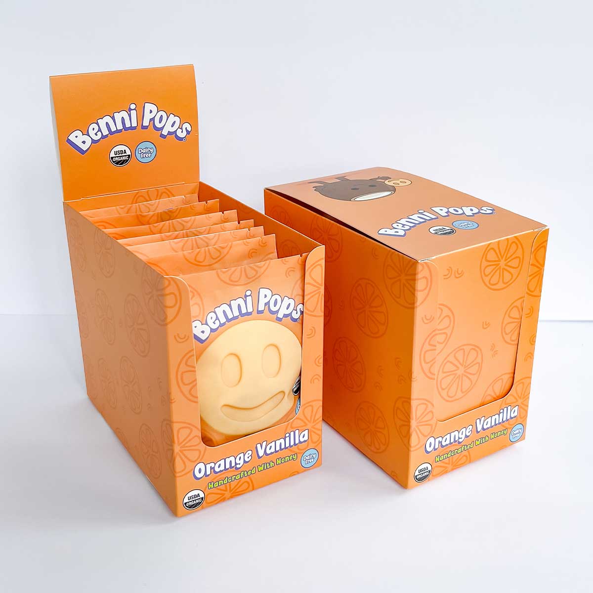 Benni Pops Orange Vanilla is an organic, dairy-free frozen dessert made with honey and bright citrus-vanilla flavor. The image shows the Orange Vanilla flavor in its colorful Benni Pops retail display box with branded case packaging.