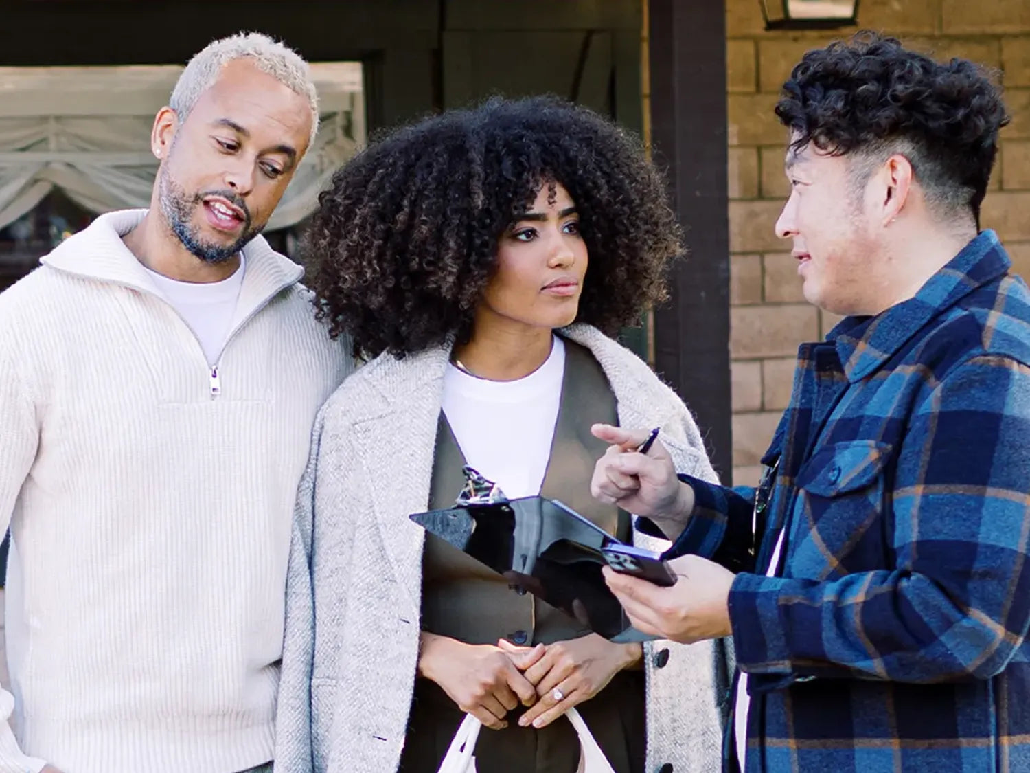 Three people talking together outdoors, capturing a candid moment of conversation and connection