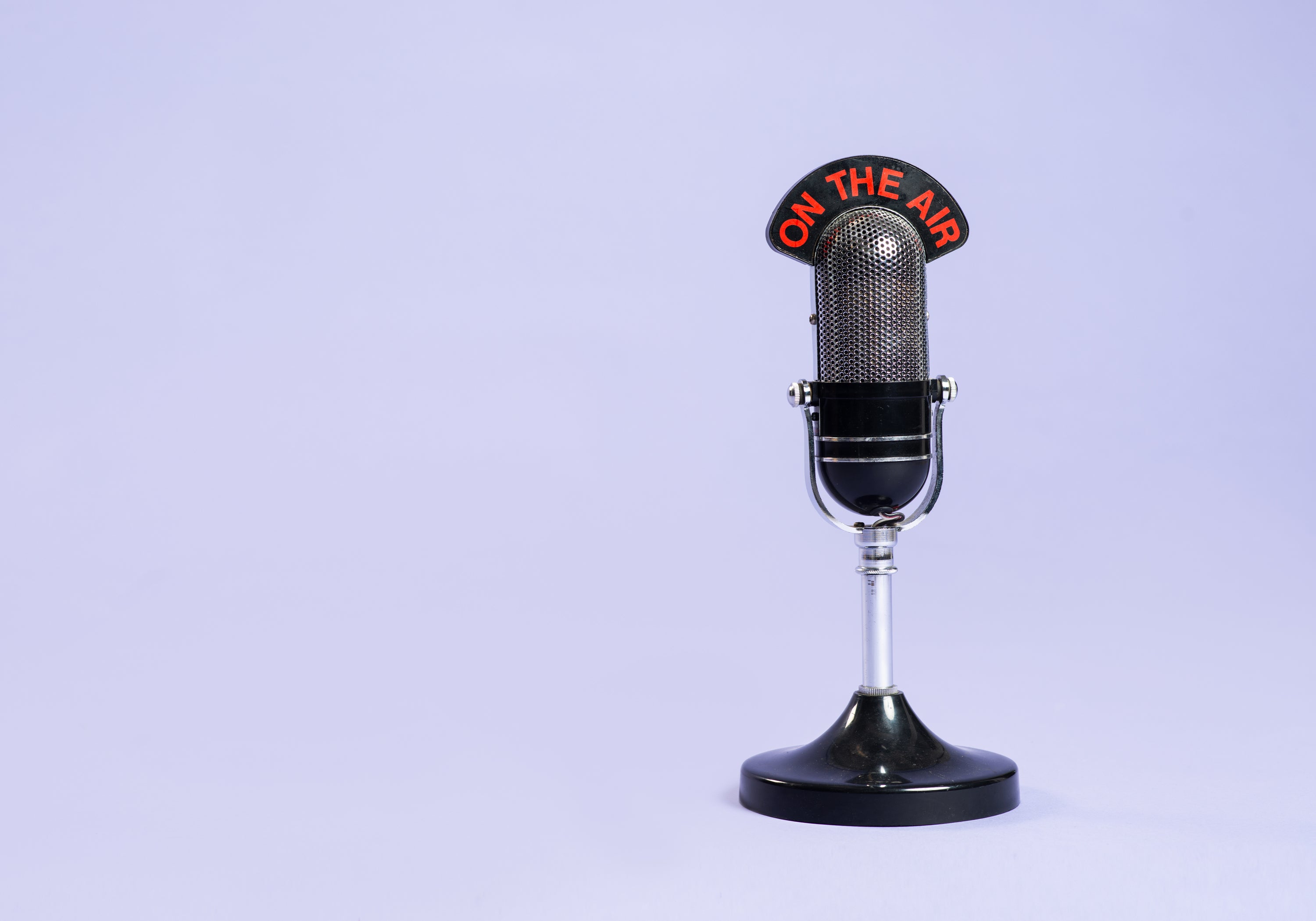 Vintage-style microphone on a stand against a clean background, representing media features, interviews, or press coverage